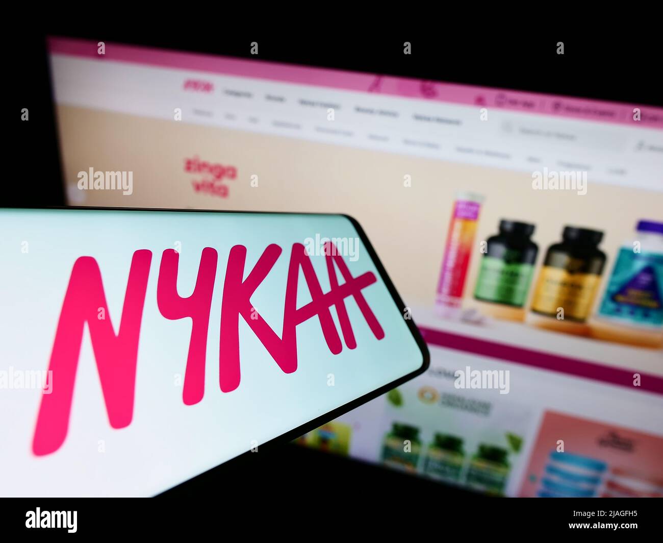 Mobile phone with logo of e-commerce company Nykaa E-Retail Pvt. Ltd. on screen in front of website. Focus on center-right of phone display. Stock Photo