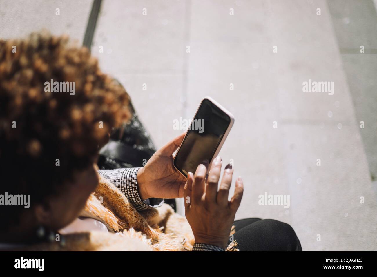 Senior woman using smart phone during sunny day Stock Photo