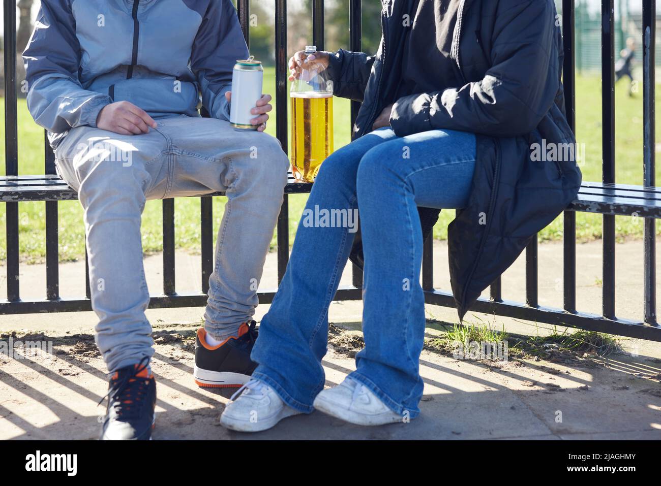 Close Up Of Underage Teenagers Drinking Alcohol In Park Stock Photo