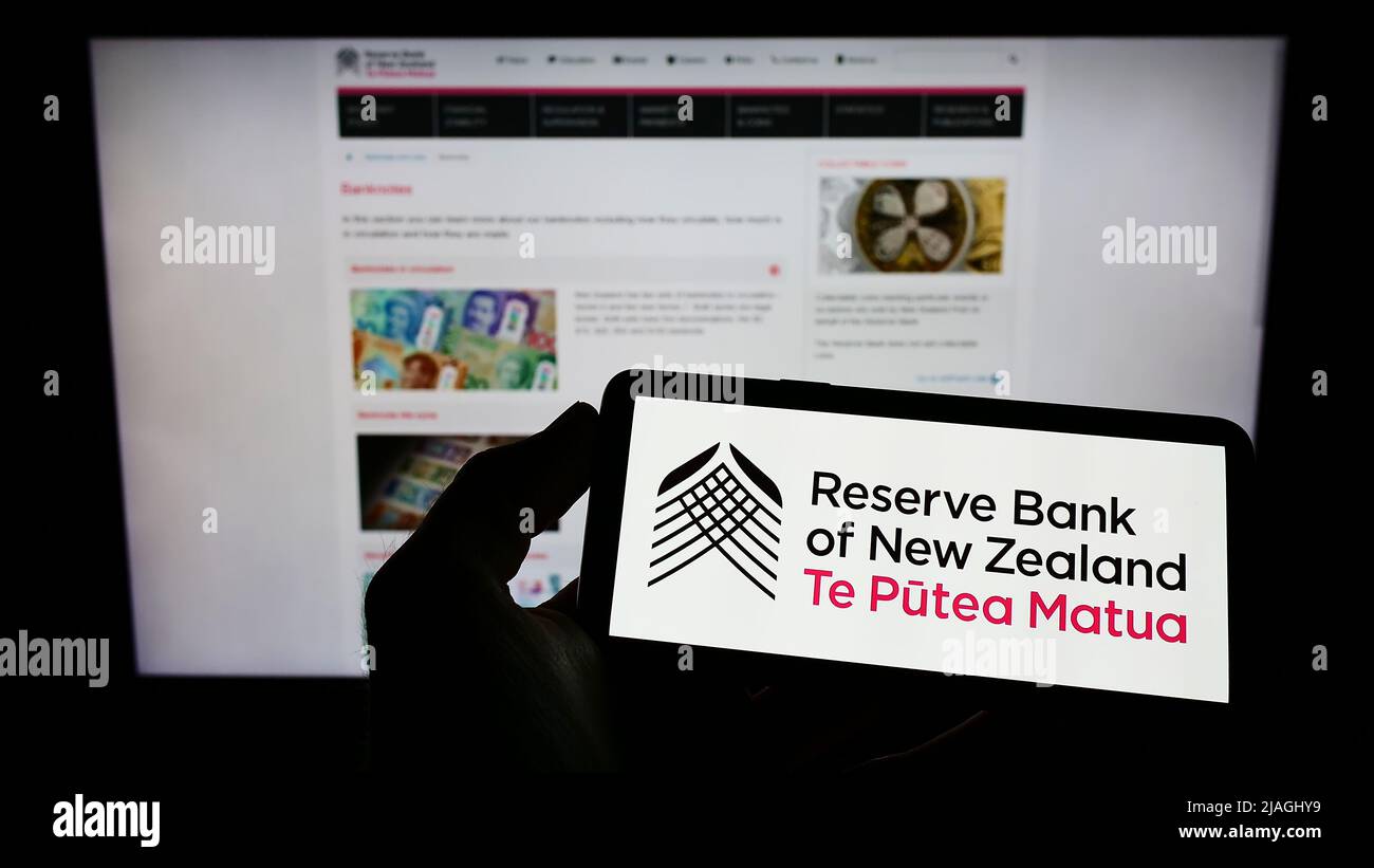 Person holding mobile phone with logo of central bank Reserve Bank of ...