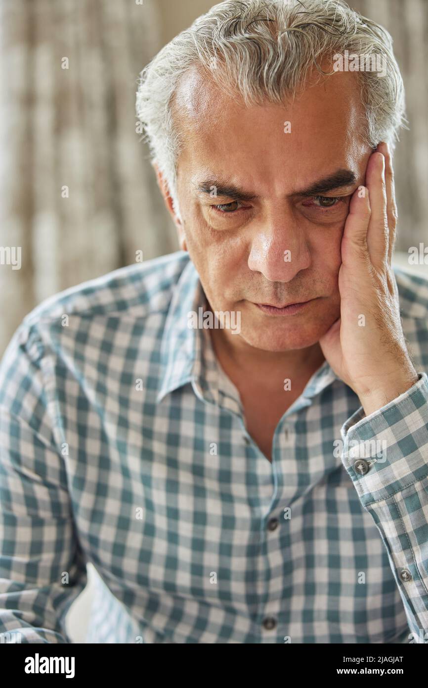 Head And Shoulders Shot Of Worried Senior Man At Home Stock Photo
