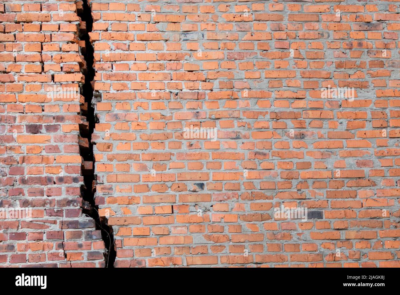 Red brick old wall with huge black crack Stock Photo