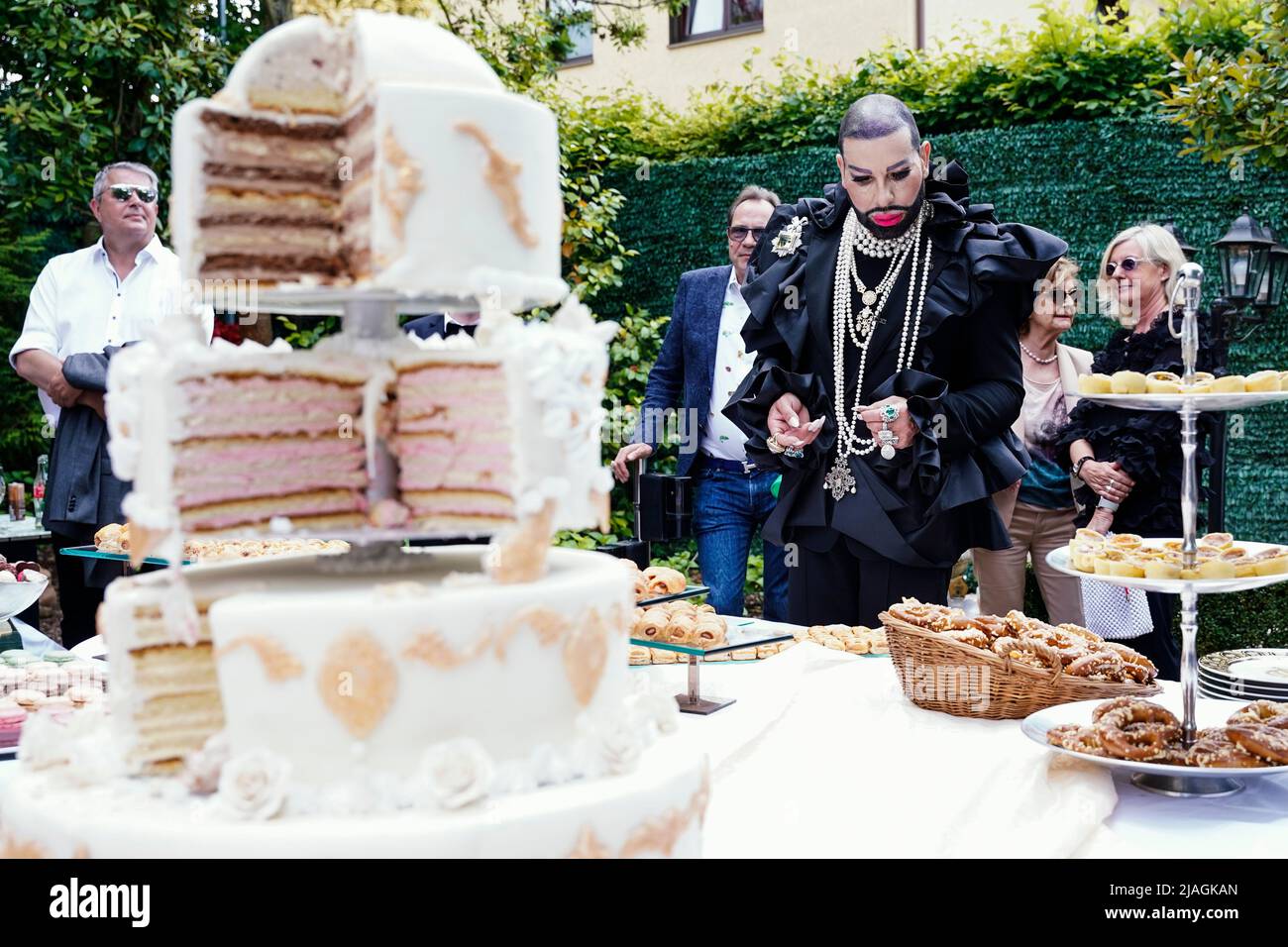 30 May 2022, Rhineland-Palatinate, Kirchheim an der Weinstraße: Harald  Glööckler, fashion designer, stands behind the birthday cake at his  birthday party in the garden of his house. Glööckler celebrates his 57th  birthday