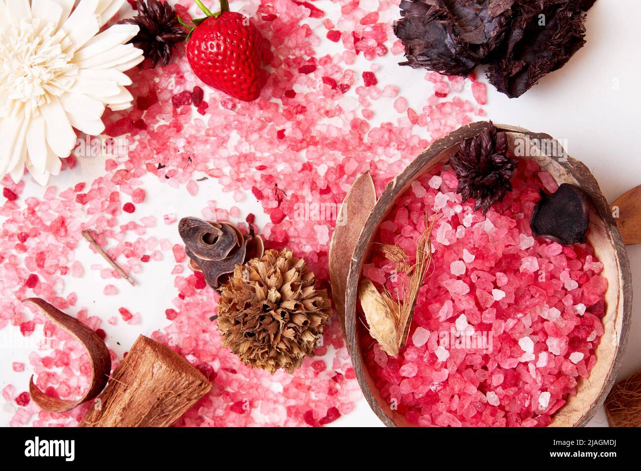 Magnesium pink bath salt, dried herbs, flowers and coconut in spa salon