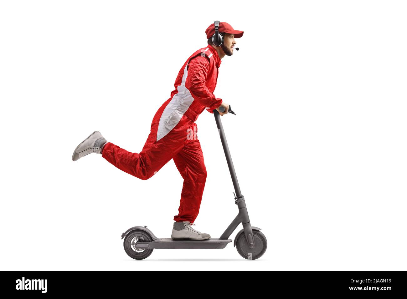 Full length profile shot of a racer in a red suit riding an electric scooter isolated on white background Stock Photo
