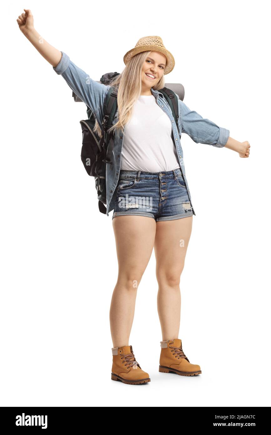 Full length portrait of a young female backpacker smiling and gesturing ...