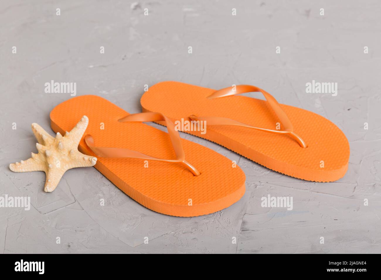 Beach accessories. Flip flops and starfish on colored background. Top ...