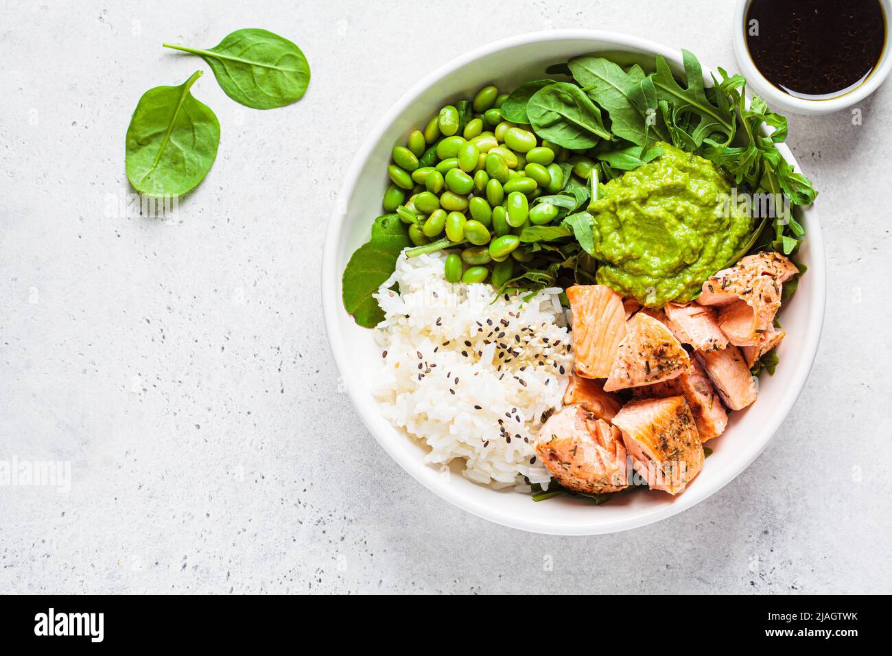 Fried salmon salad with rice, edamame and guacamole, top view. Cooked