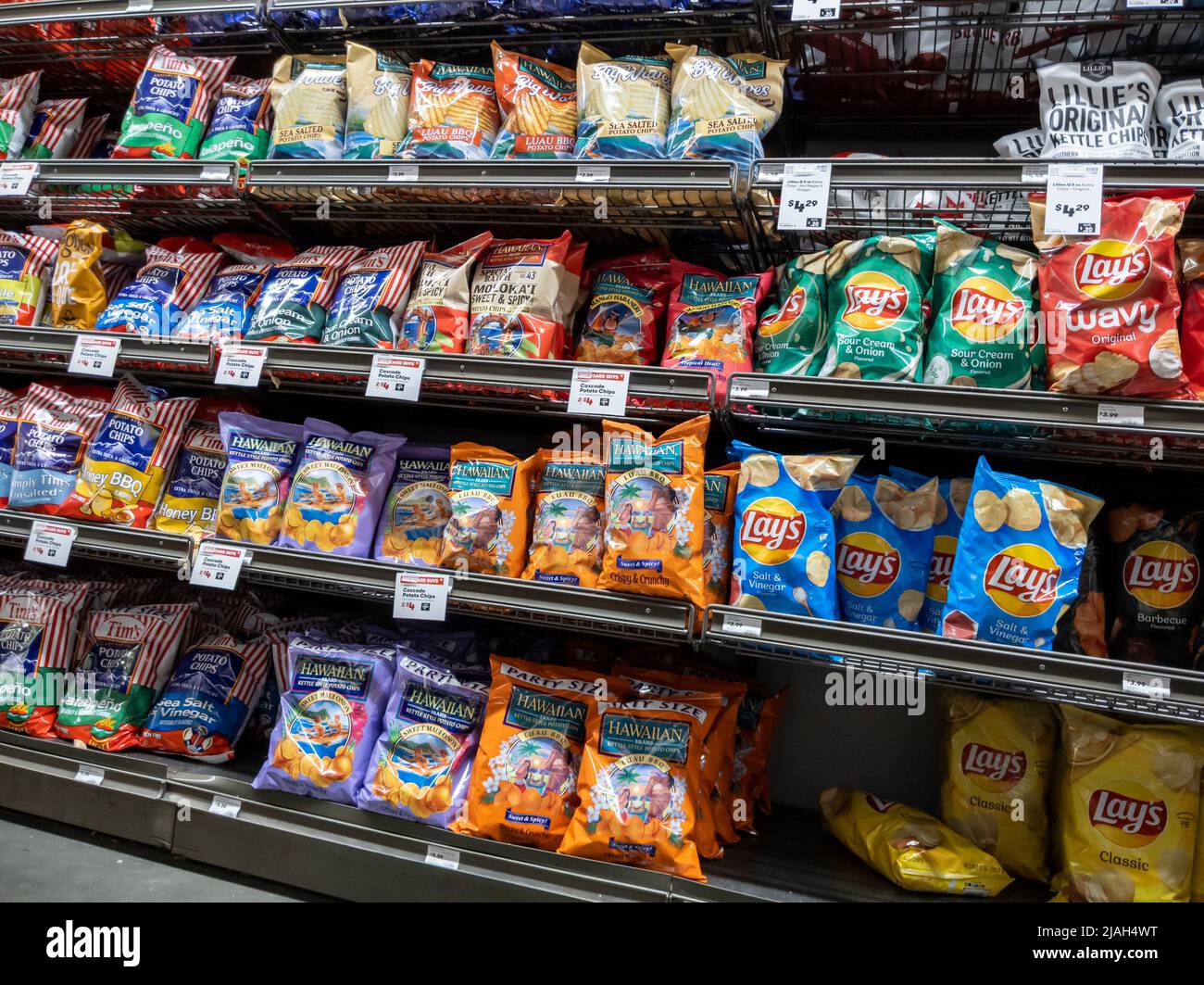 Mill Creek, WA USA - circa May 2022: Angled view of Tim's, Hawaiian, and Lays potato chips for sale inside a Town and Country Market. Stock Photo