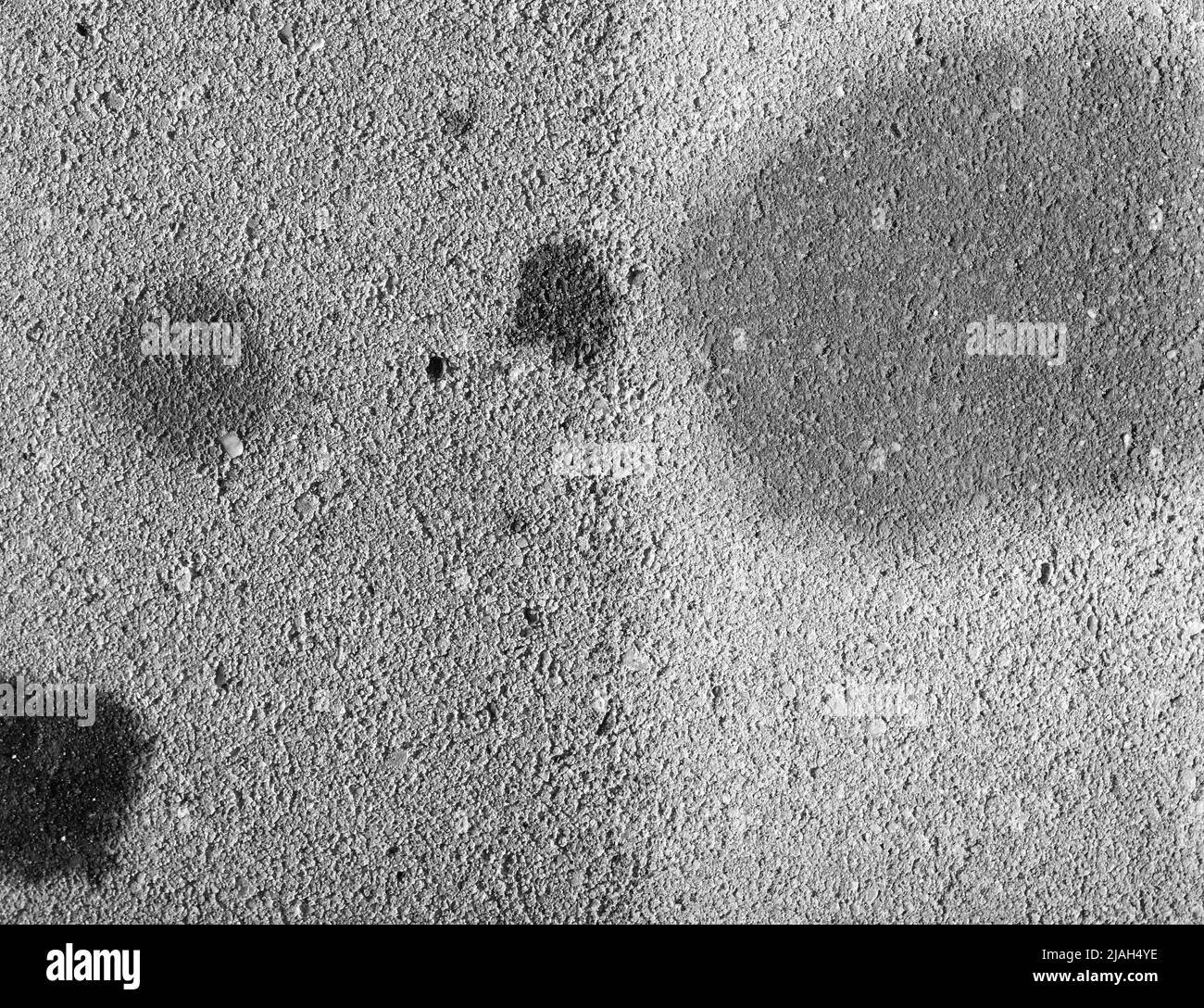 Oil stains on concrete caused by cars. Black engine oil on concrete floor. Engine oil leak from