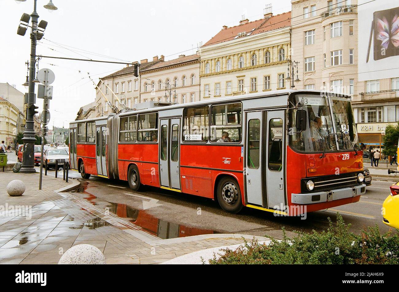 Red old european trolley bus on the busy city street in Budapest riding