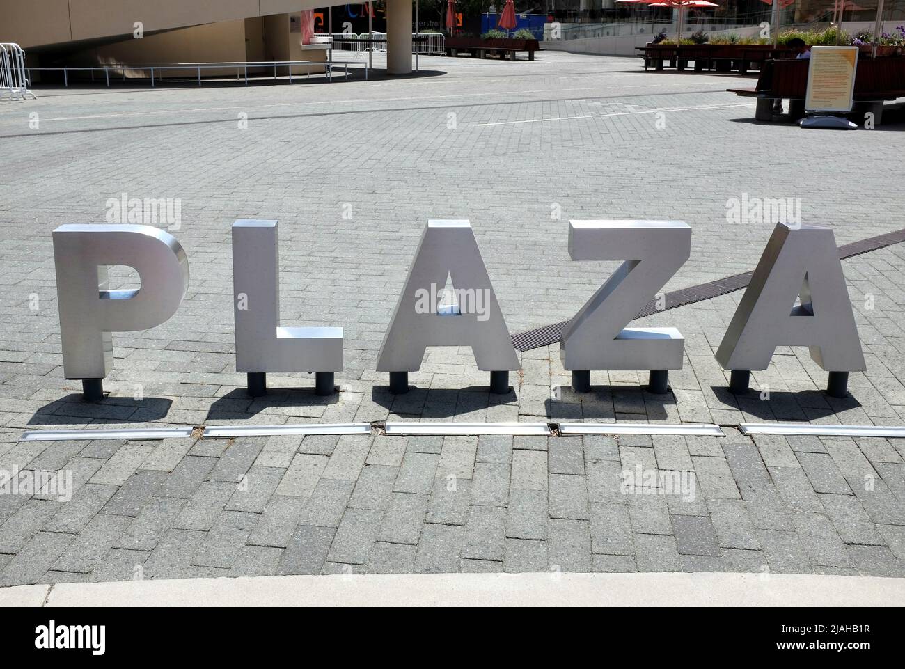 COSTA MESA, CALIFORNIA - 8 MAY 2021: Plaza sign at Argyros Plaza, a public gathering place that offers free events and performances, between Segerstro Stock Photo