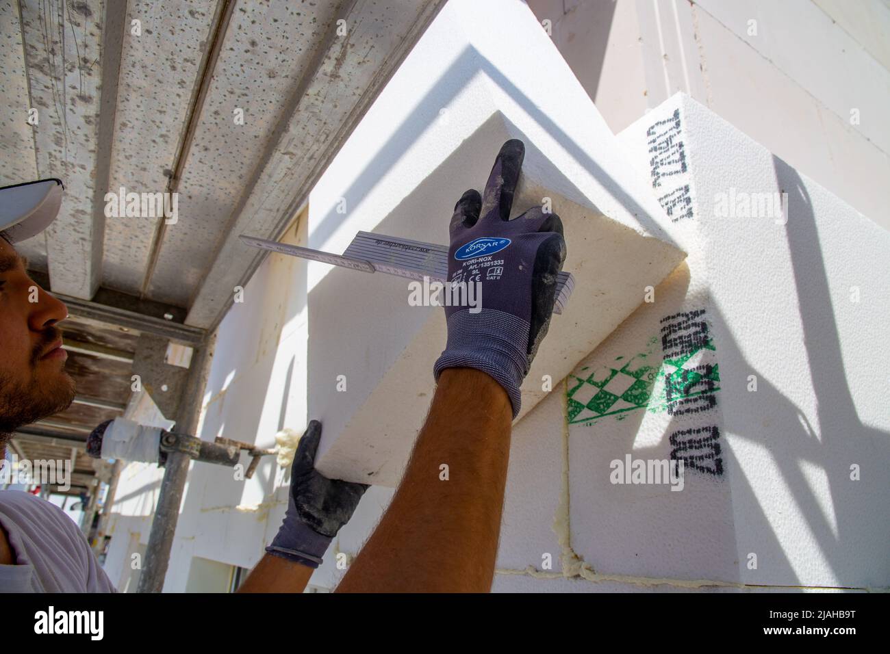 Construction workers insulates house facade Stock Photo