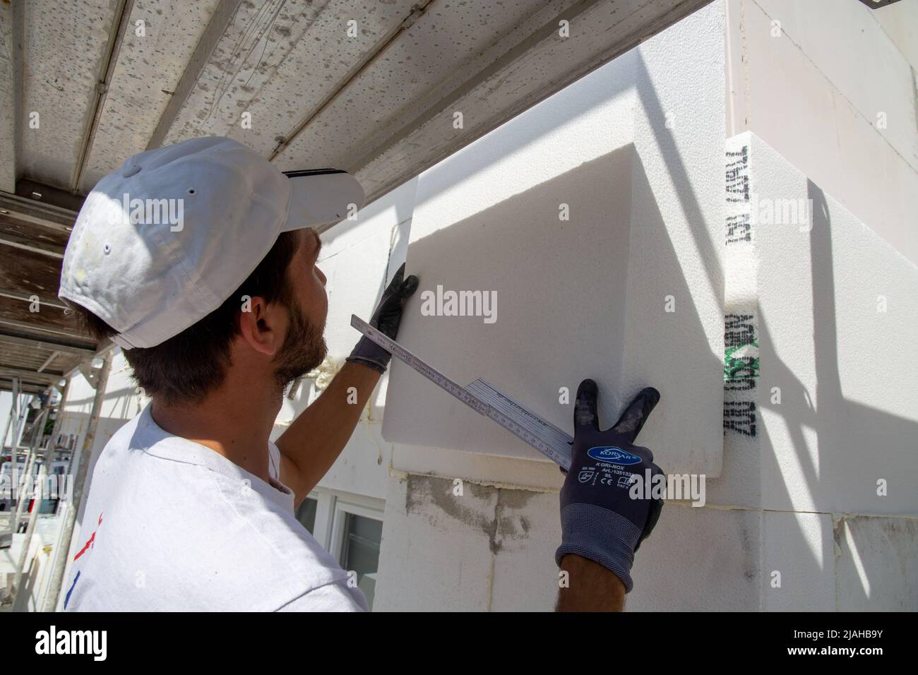 Construction workers insulates house facade Stock Photo