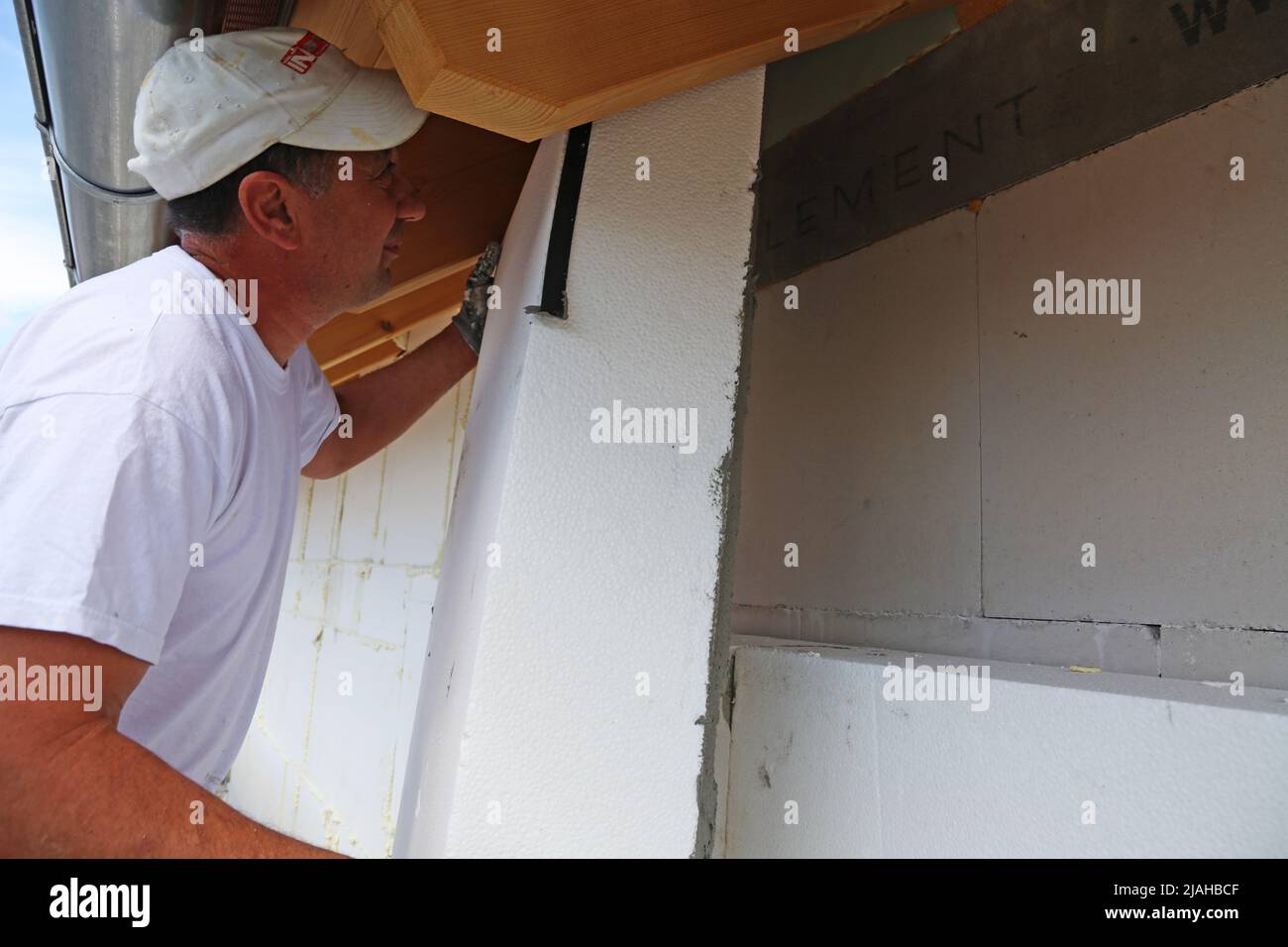 Construction workers insulates house facade Stock Photo