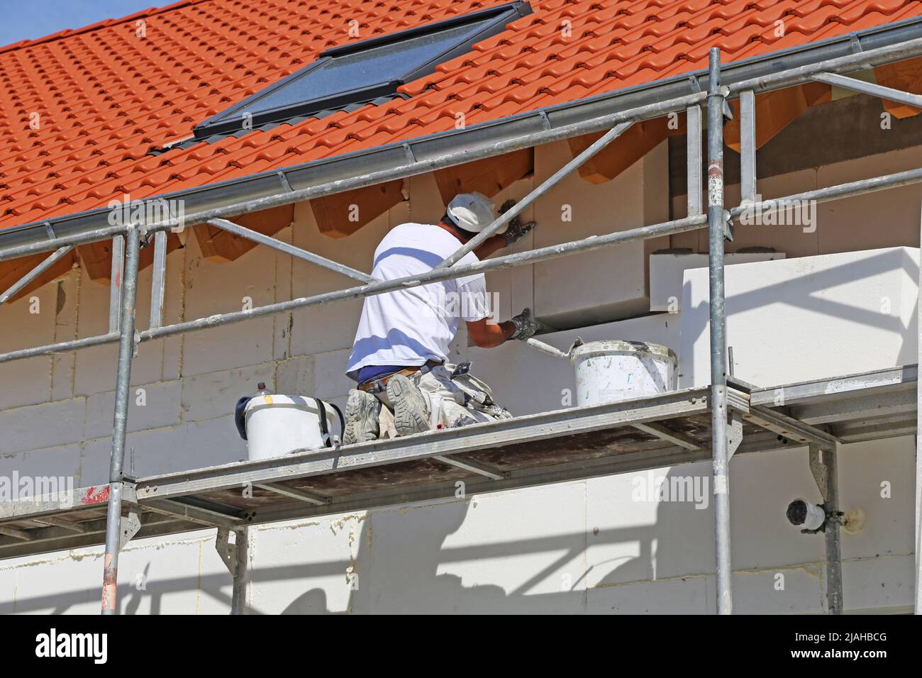 Construction workers insulates house facade Stock Photo