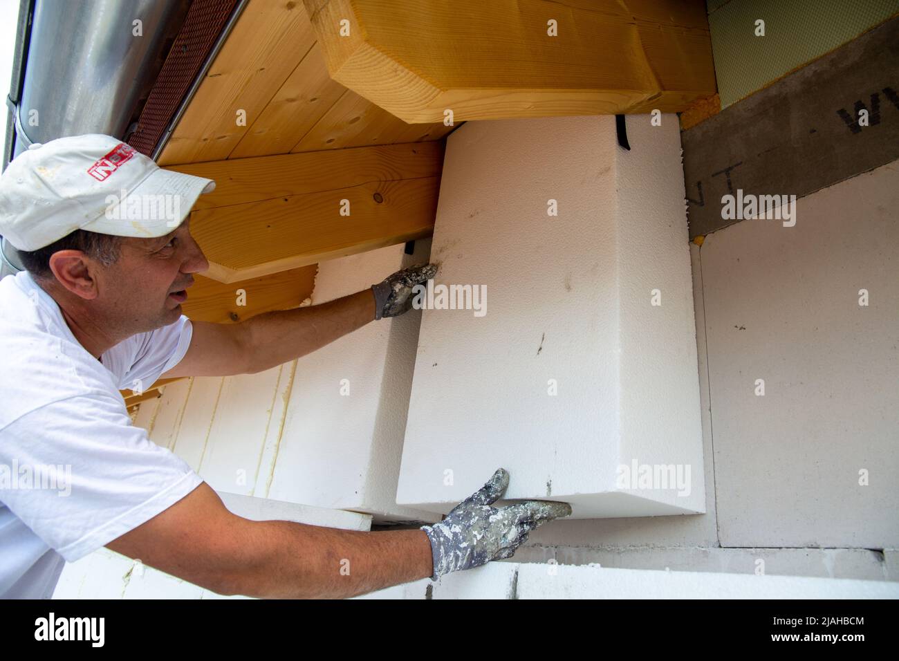 Construction workers insulates house facade Stock Photo