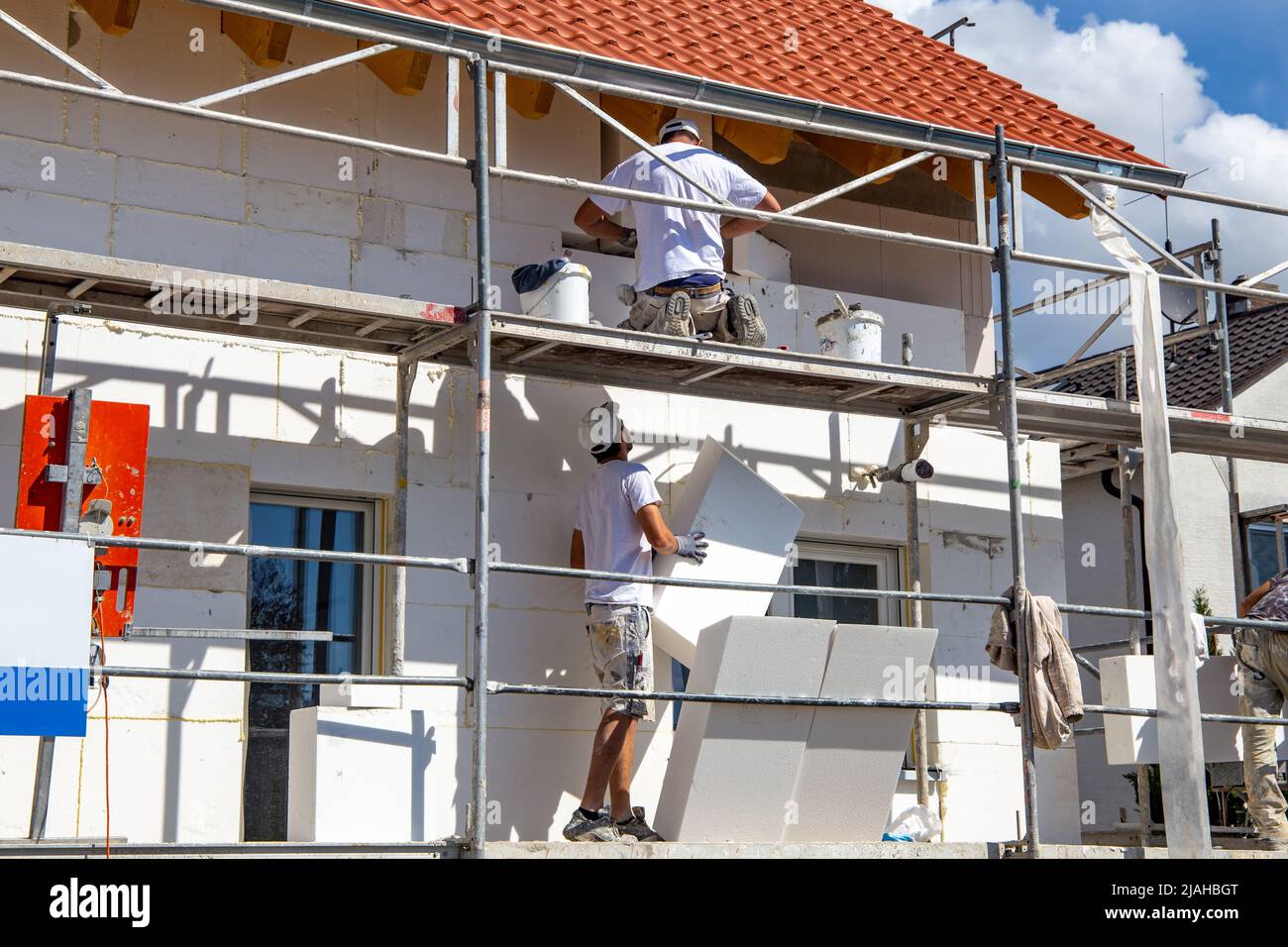 Construction workers insulates house facade Stock Photo