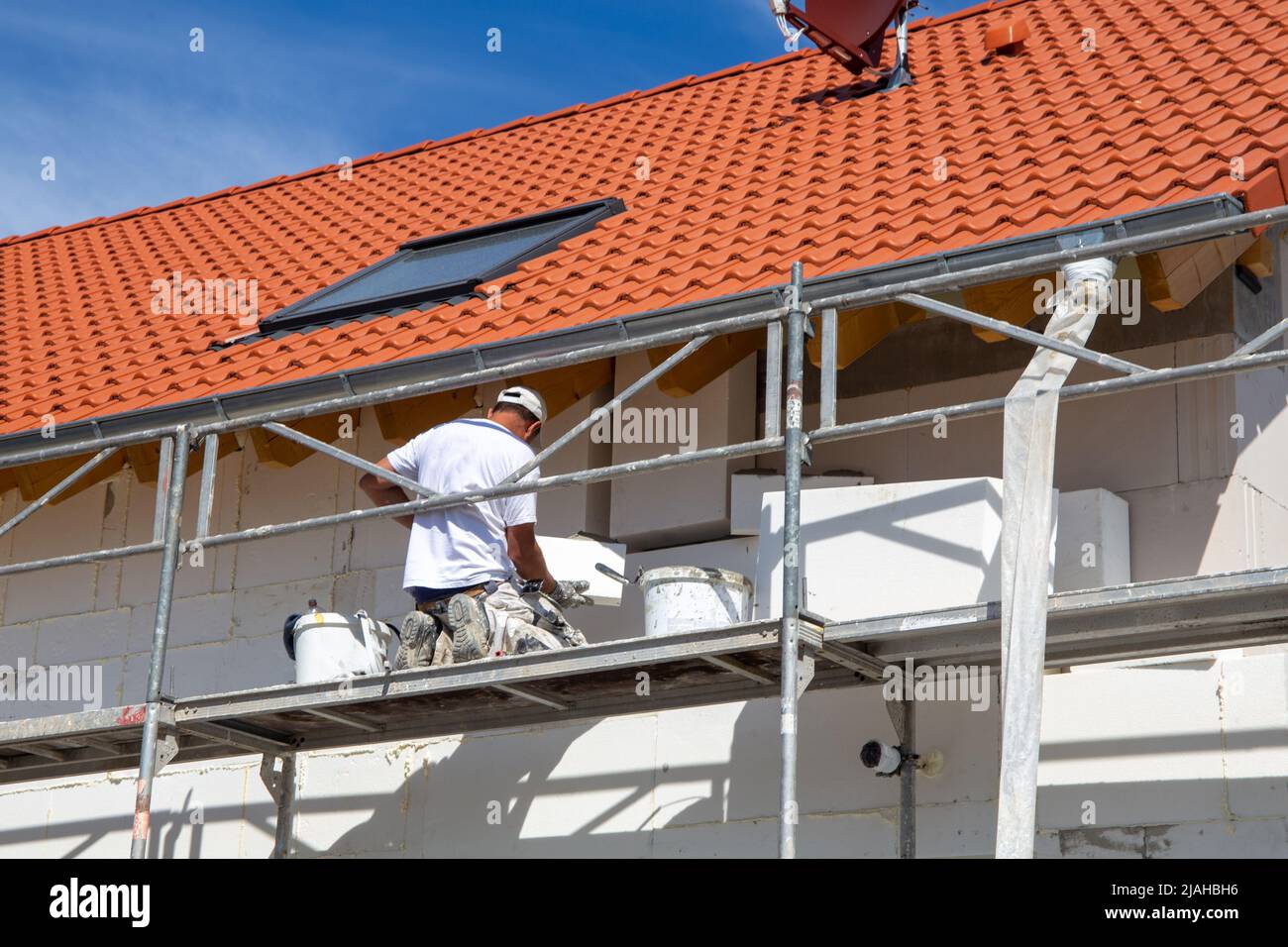 Construction workers insulates house facade Stock Photo