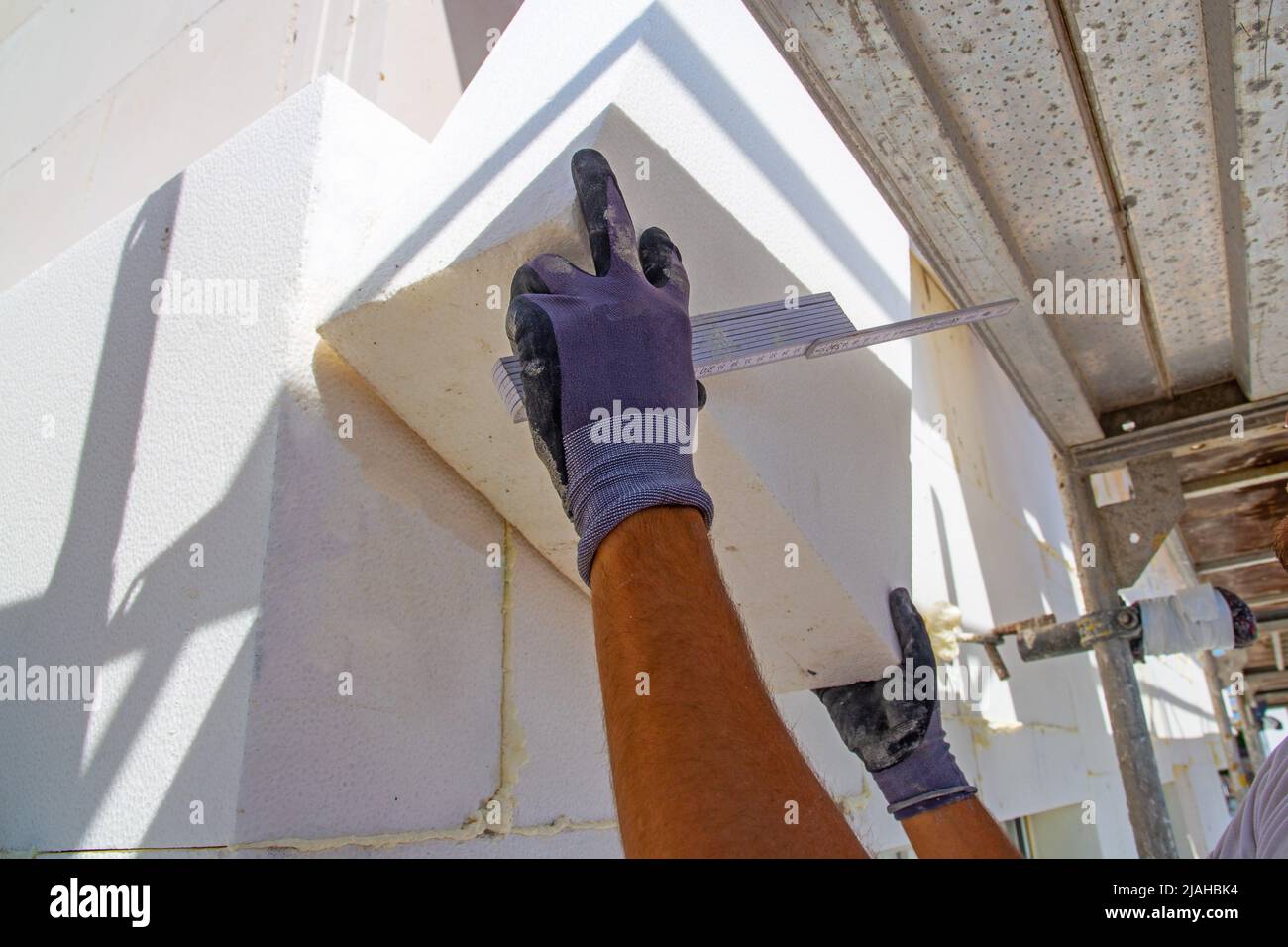 Construction workers insulates house facade Stock Photo