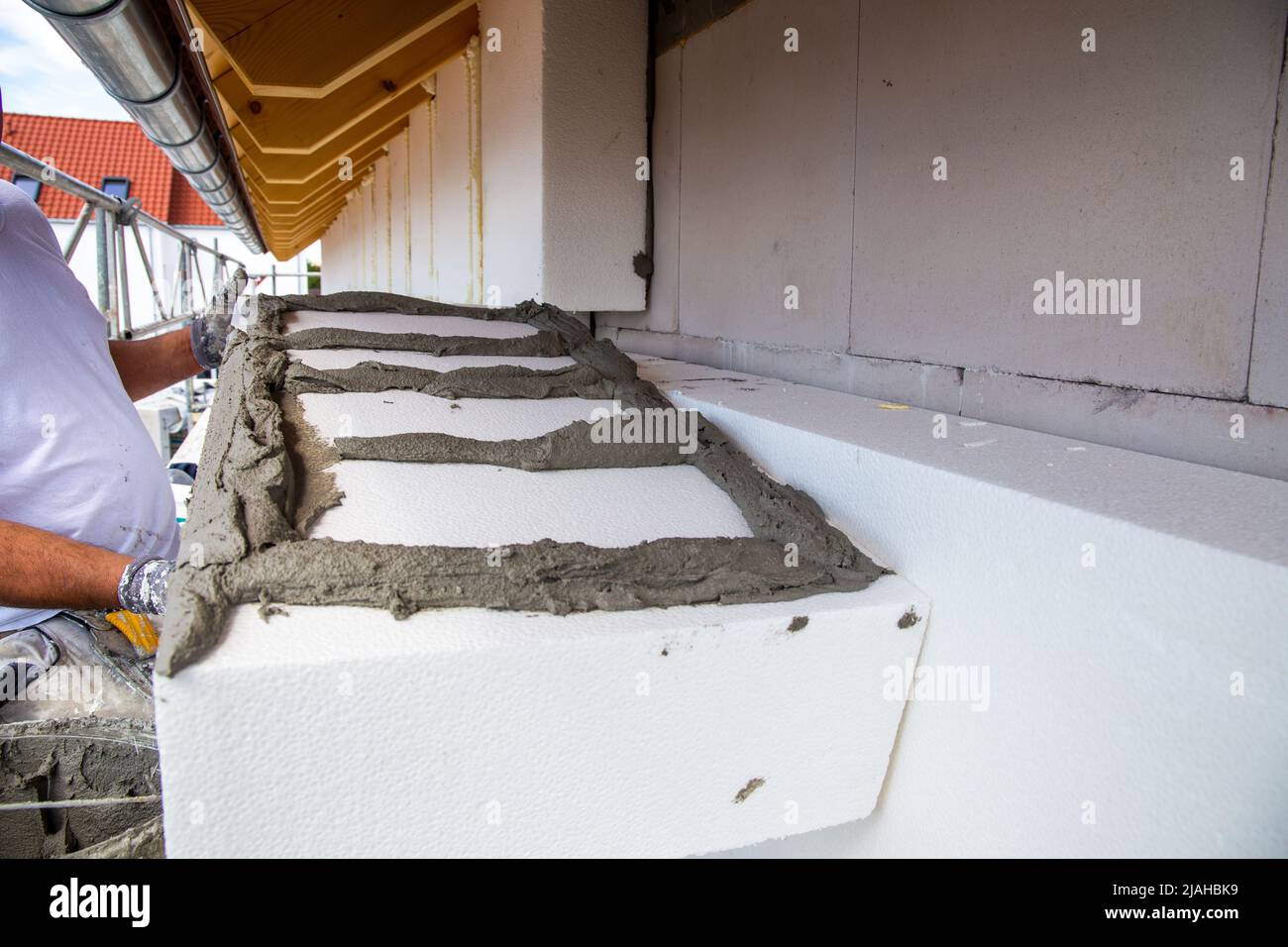 Construction workers insulates house facade Stock Photo