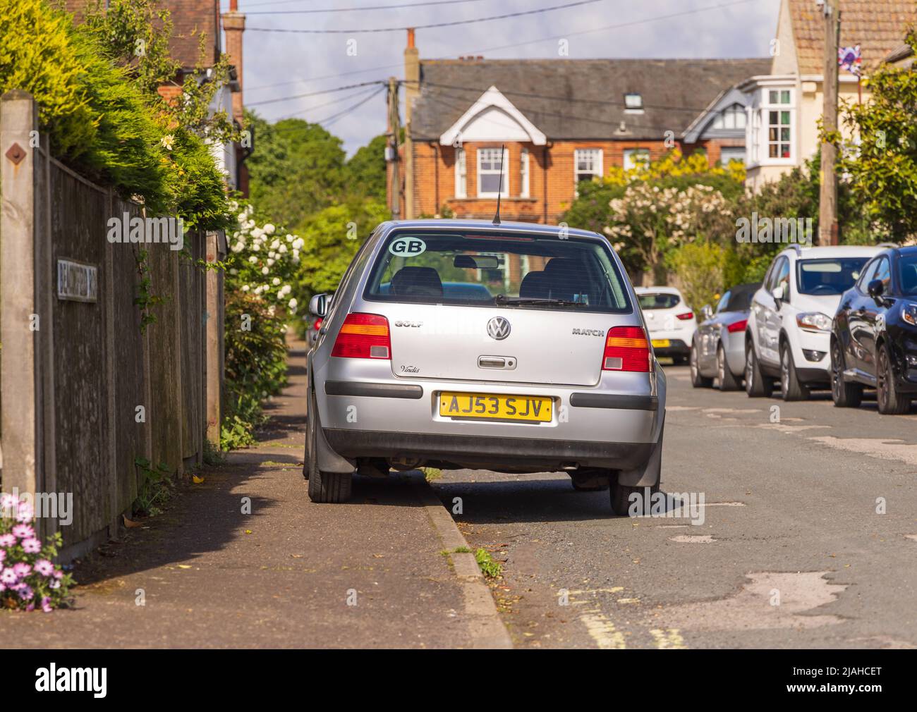 A car parked on a pavement, causing an obstruction for pedestrians. Aldeburgh, Suffolk. UK Stock Photo