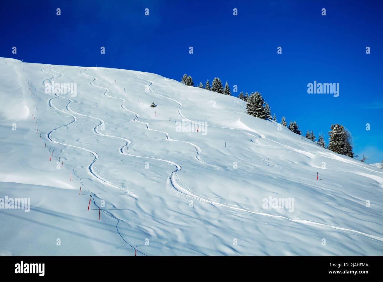 Traces from off-piste snowboarding on a mountain over blue sky Stock Photo