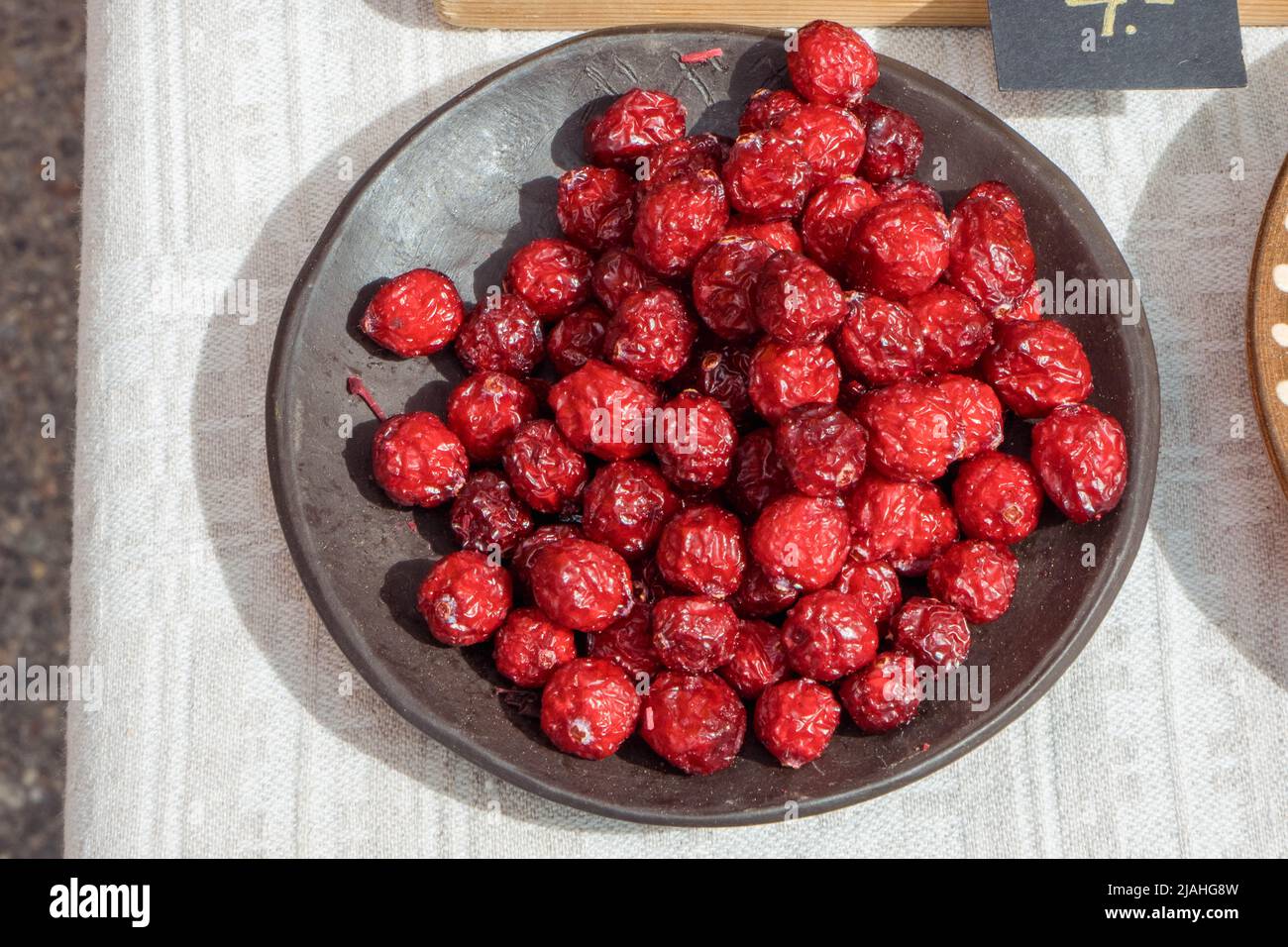 Dried cranberries in blue bowl top view. Healthy tasty dry red berries