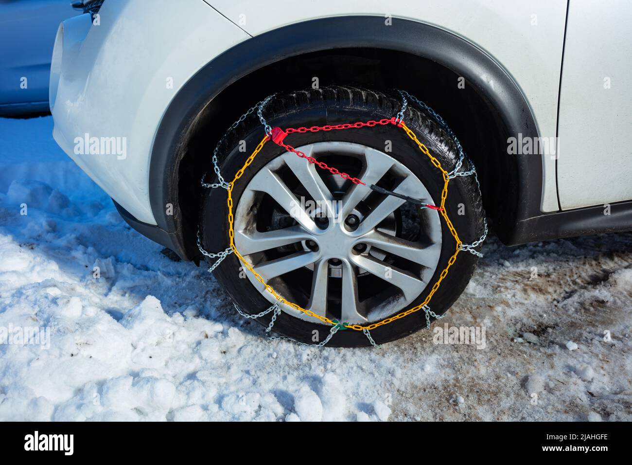 Snow chains on a car wheel close-up from side Stock Photo