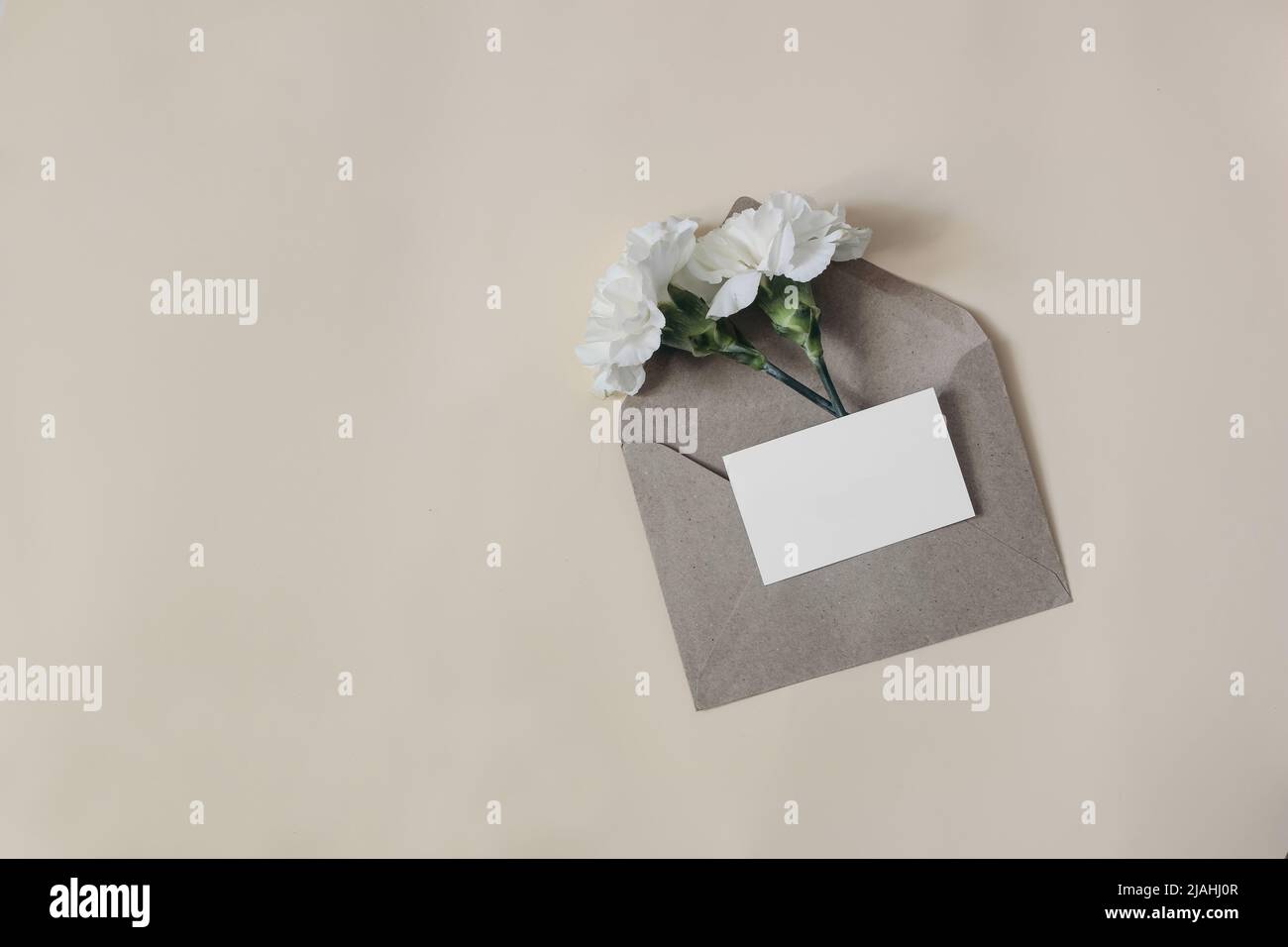 Feminine wedding, birthday stationery composition. Blank business card, invitation mockup with craft envelope isolated on beige table background Stock Photo