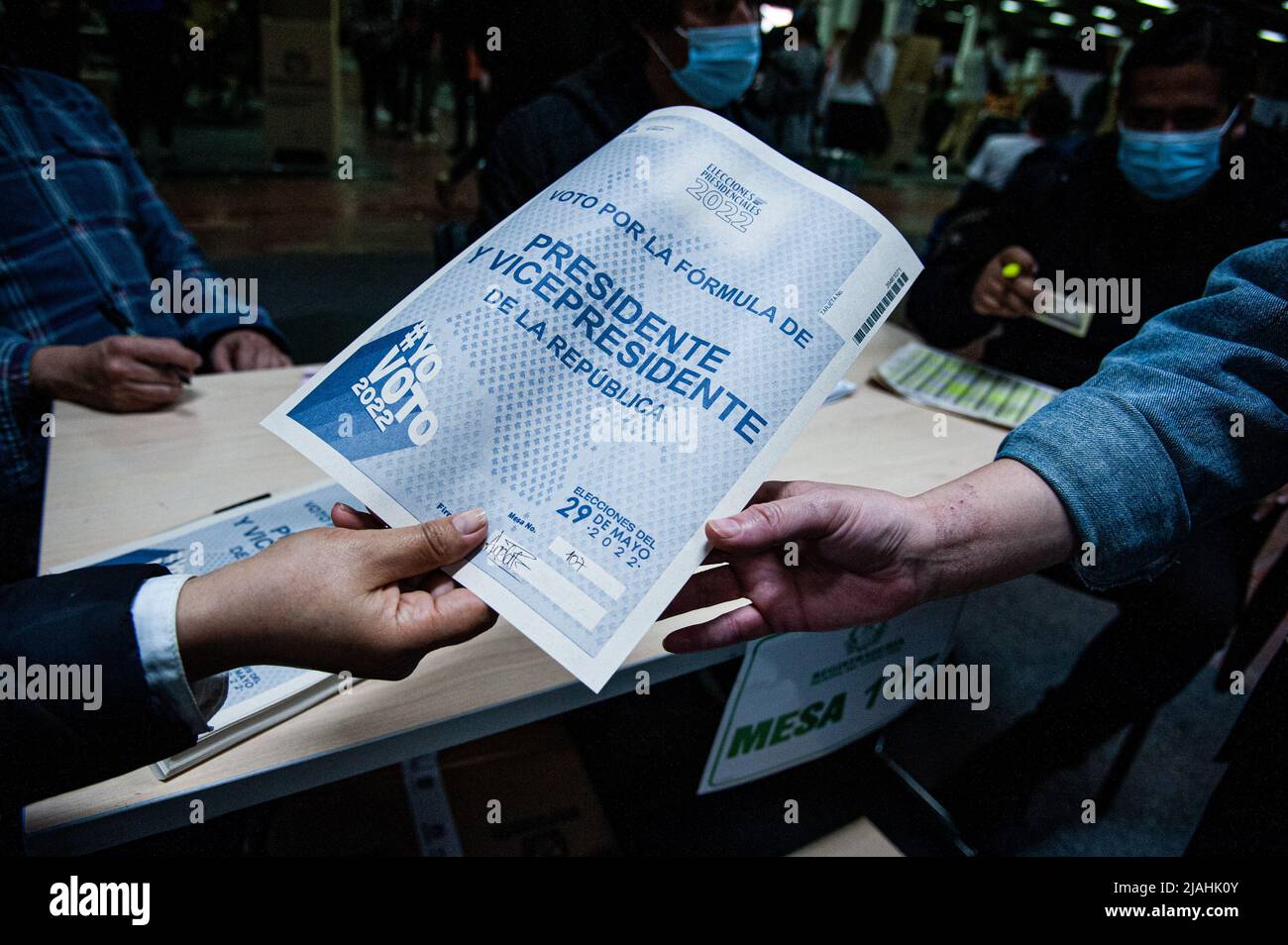 Electoral jury hands the presidential election ballots to voters during the 2022 Presidential elections in Bogota, Colombia on May 29, 2022. Stock Photo