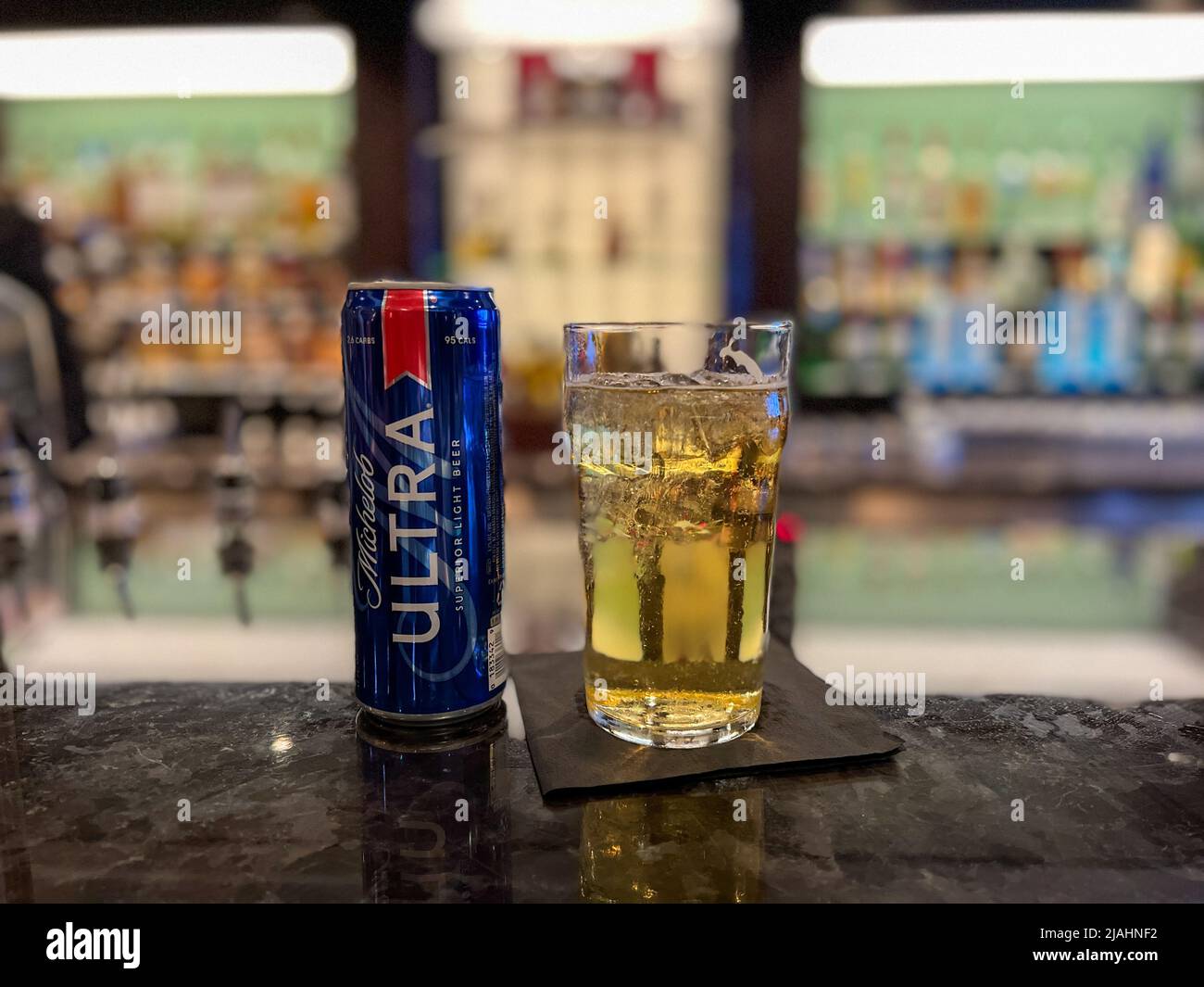 Orlando, FL USA-January 10, 2022:   A can of Michelob Ultra Beer and a glass on a counter on a bar. Stock Photo