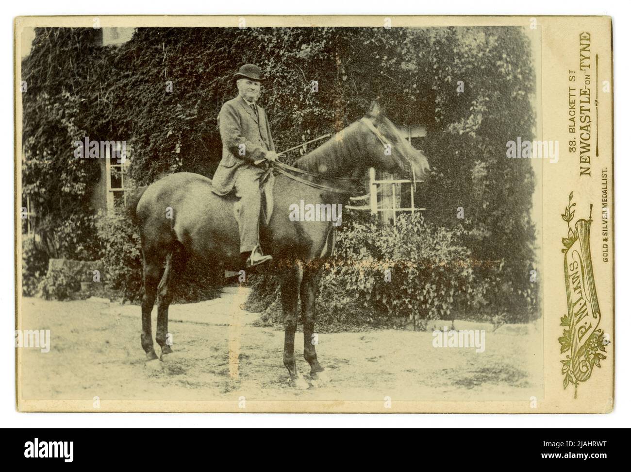 Original charming cabinet card outdoors portrait of a country gentleman on his horse outside his home,  photographed by P.M. Laws, 38 Blackett St. Newcastle-upon-Tyne, England, U.K. late 1880's, early 1890's. Stock Photo