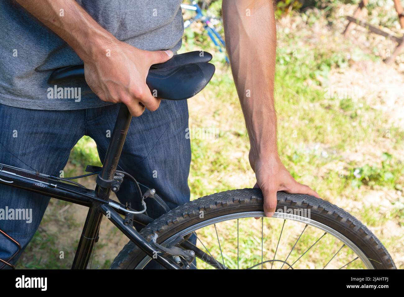 Close-up of a man mounting a bike's wheel Stock Photo