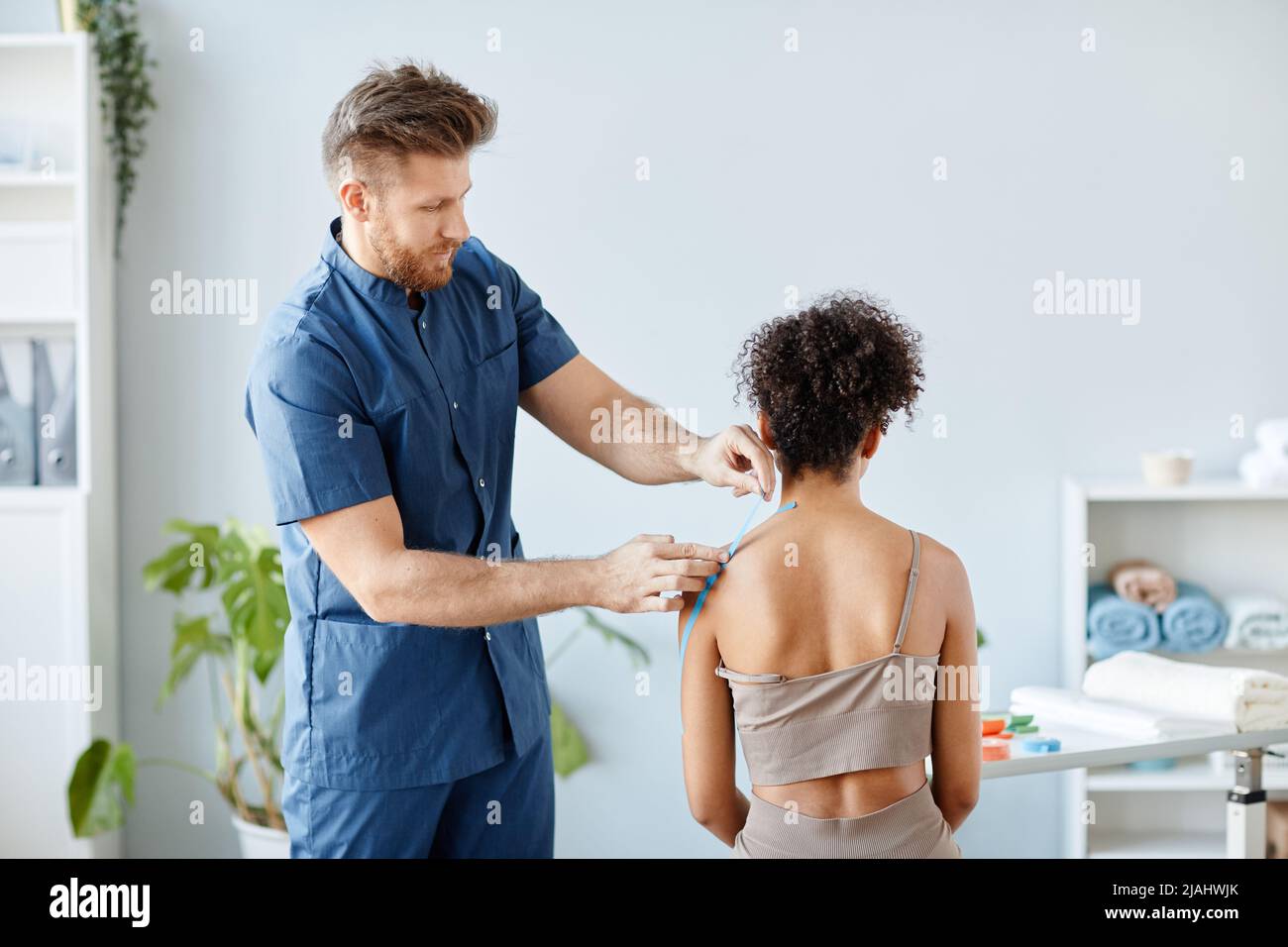 Side view portrait of rehabilitation therapist putting physio tape on