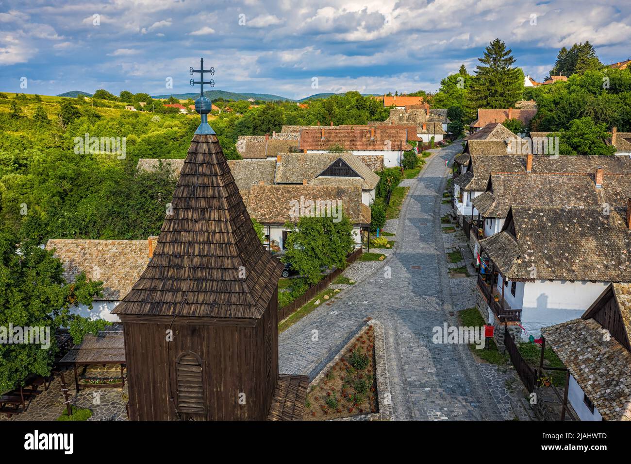 Holloko, Hungary - Aerial view of the tower of the traditional catholic church of Holloko at the village centre, an UNESCO site in Hungary on a sunny Stock Photo