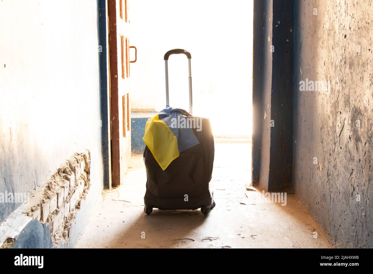 A suitcase with the flag of Ukraine stands in the entrance of the house, people leave their homes because of the war, Ukrainian refugees, the war in U Stock Photo
