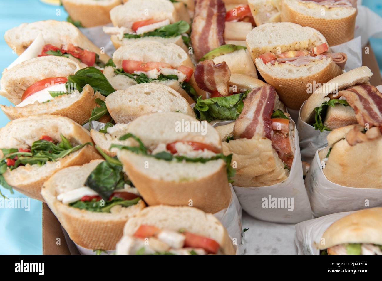 Submarine sandwiches are made and individually wrapped and cut for each member of the birthday party to eat. Stock Photo