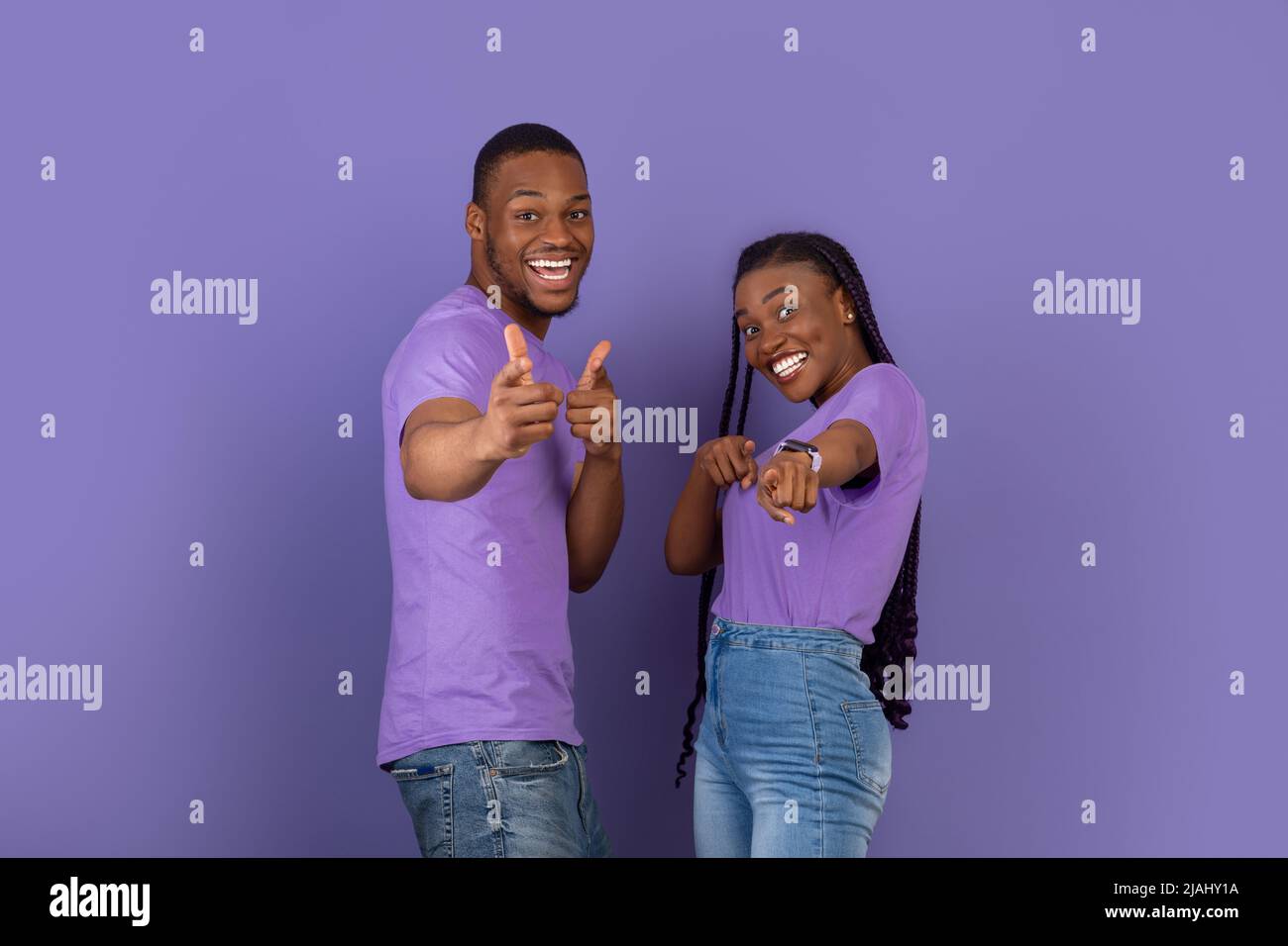 Excited black guy and lady pointing fingers at camera Stock Photo