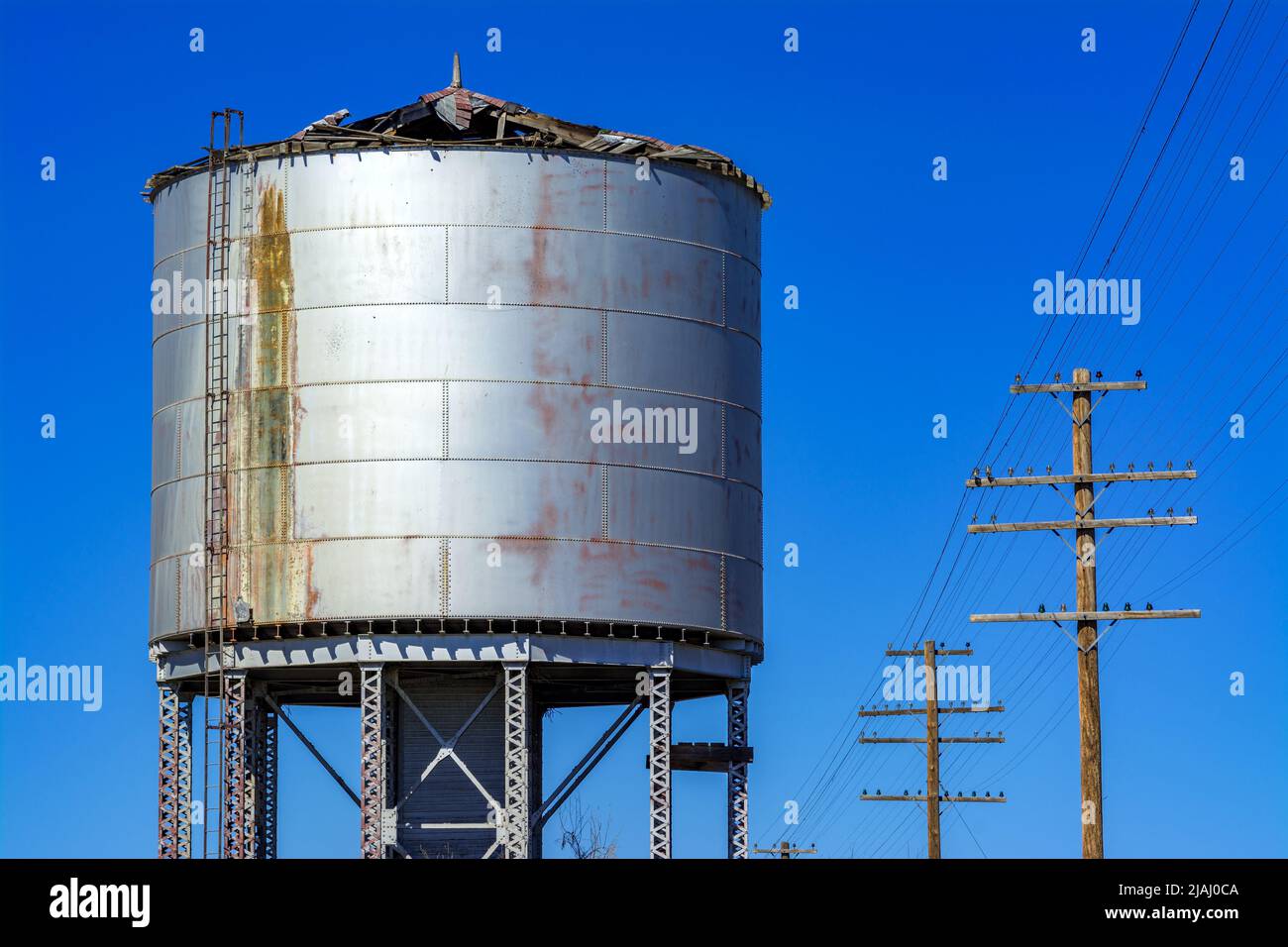 Railroad water tank with clue sky and power lines Stock Photo