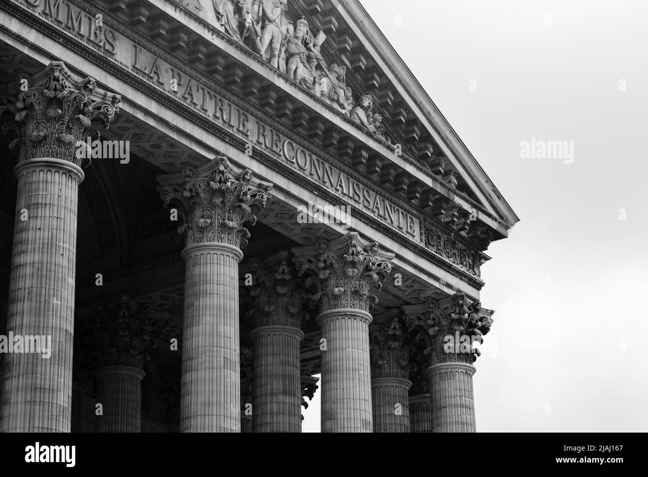 Black and white image of the pediment from the Pantheon in Paris, France.  Showing just the top corner of roof and a few of the columns. Stock Photo