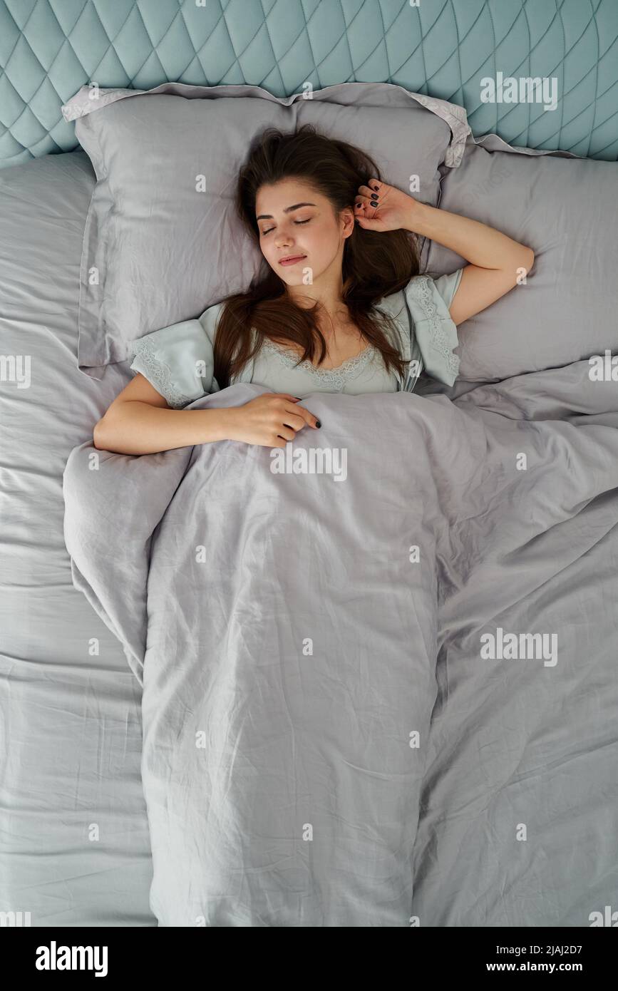 Beautiful woman sleeping in comfort bed. Rest, bed linen. Apartment. Home lifestyle Stock Photo