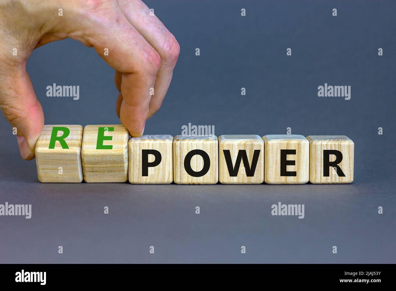 Power or repower symbol. Businessman turns wooden cubes and changes concept words Power to Repower. Beautiful grey table grey background. Business eco Stock Photo