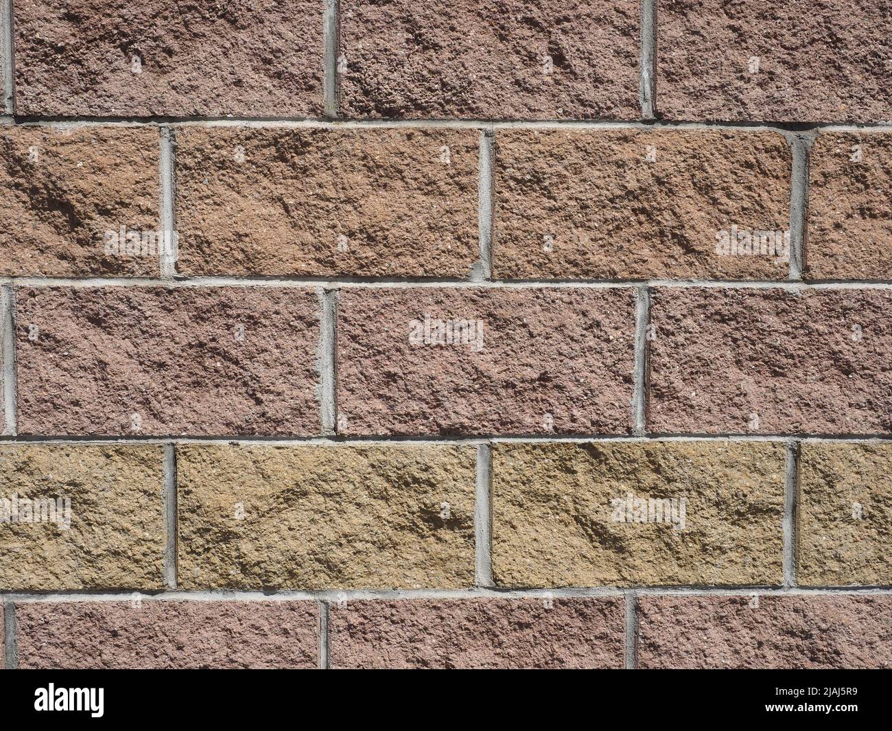 brown and yellow stone bricks wall useful as a background Stock Photo