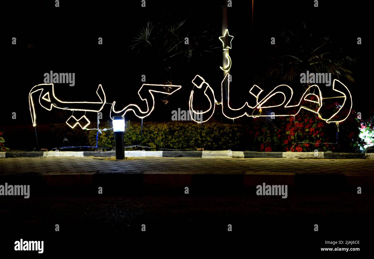 An Arabic text Ramadan Kareem, Translation (Generous Happy Ramadan) made with led lights in the street as a festive sign celebrating the holy month in Stock Photo