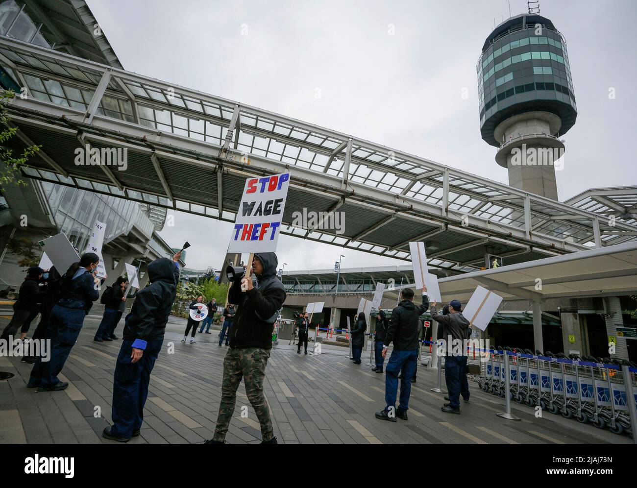 Richmond, Canada. 30th May, 2022. People hold placards during a rally at Vancouver International Airport in Richmond, British Columbia, Canada, on May 30, 2022. Security screening officers at Vancouver International Airport rallied Monday for better pay and less strenuous working conditions. Credit: Liang Sen/Xinhua/Alamy Live News Stock Photo