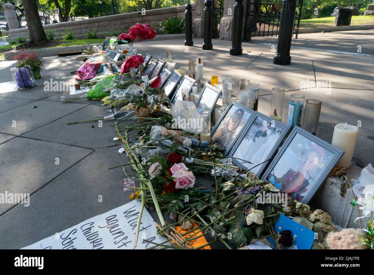 Austin Texas USA, May 30 2022: Photographs of many victims of the Uvalde, Texas mass murder at Robb Elementary lie among remembrance candles and bouquets of flowers at a makeshift memorial at the steps to the Texas Capitol grounds. Credit: Bob Daemmrich/Alamy Live News Stock Photo