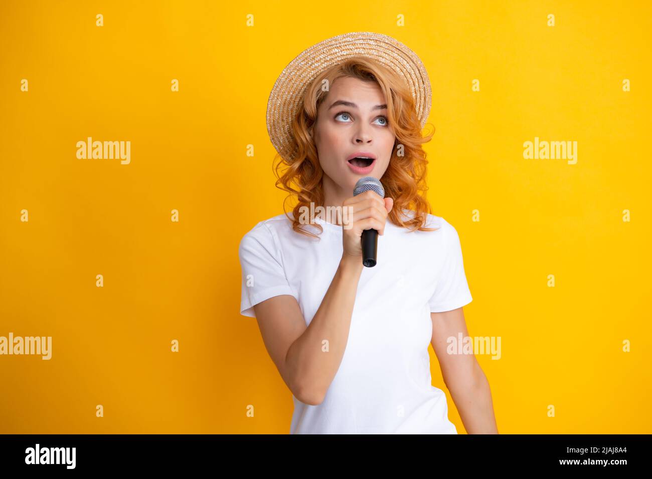 Microphone speech speaking concept. Young beautiful woman singing song using microphone. Stock Photo