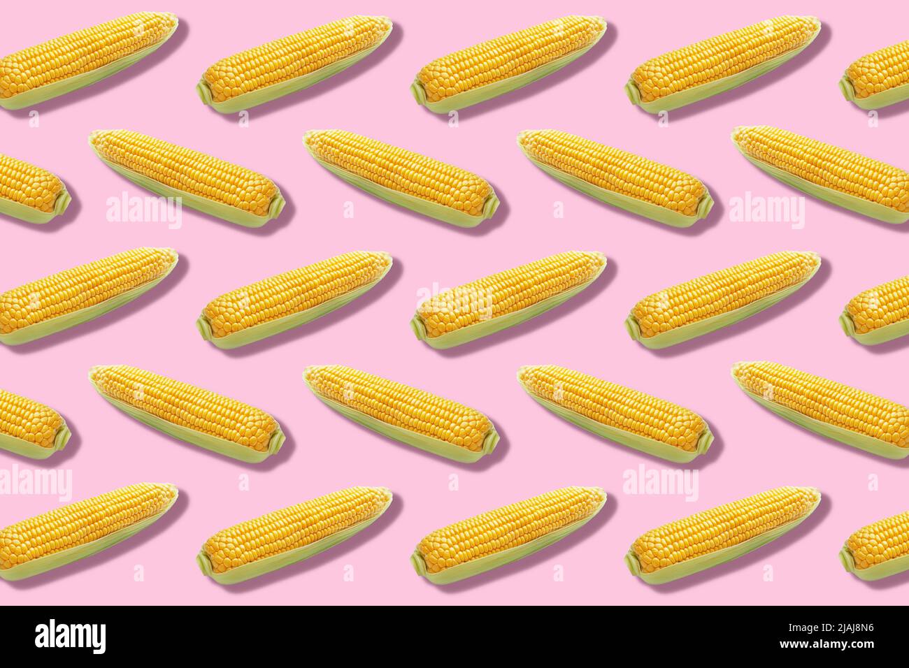 Many fresh corn cobs on pink background. Pattern for design Stock Photo ...