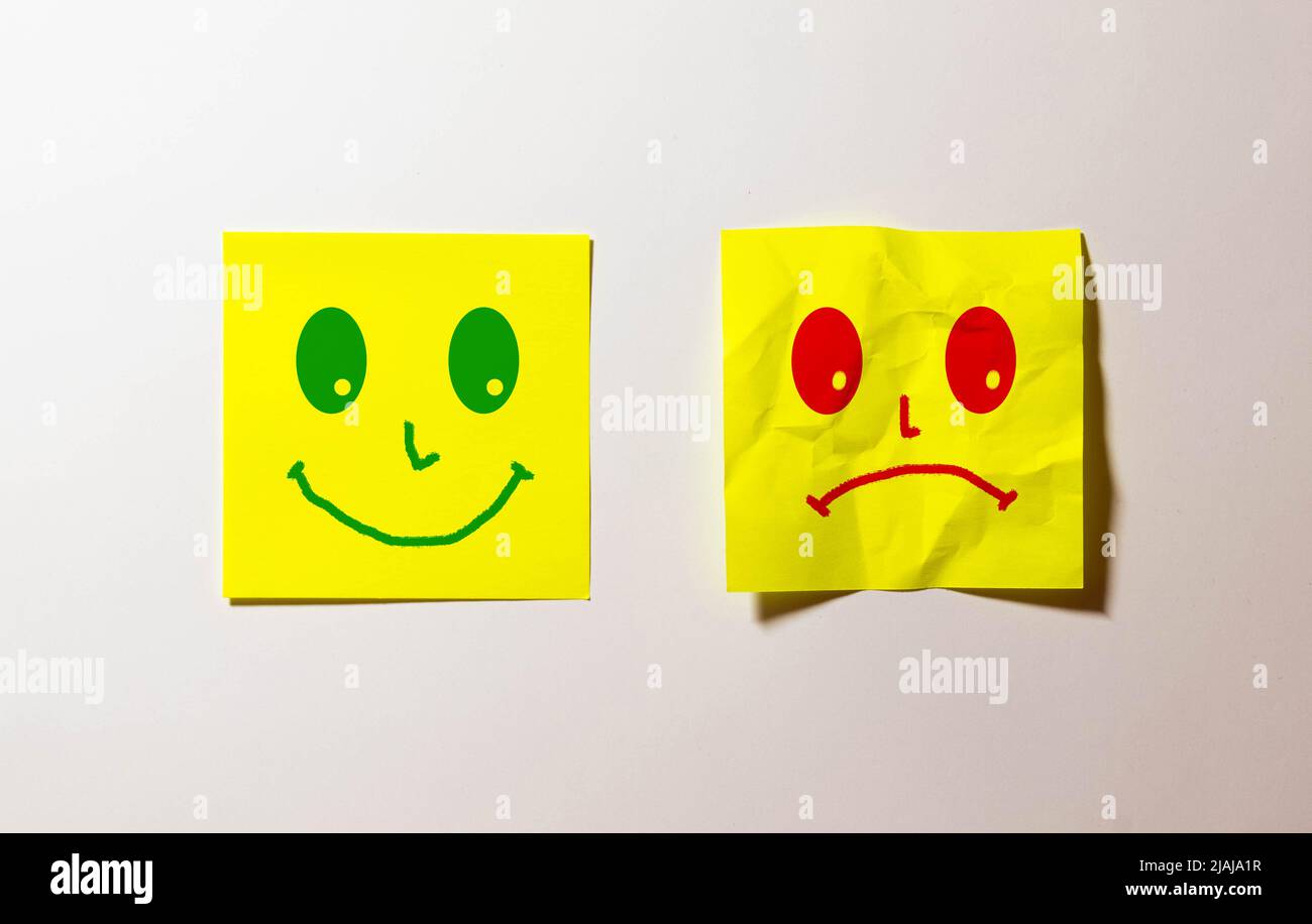 Happy and sad face, emoticons on the green back ground. Stock Photo